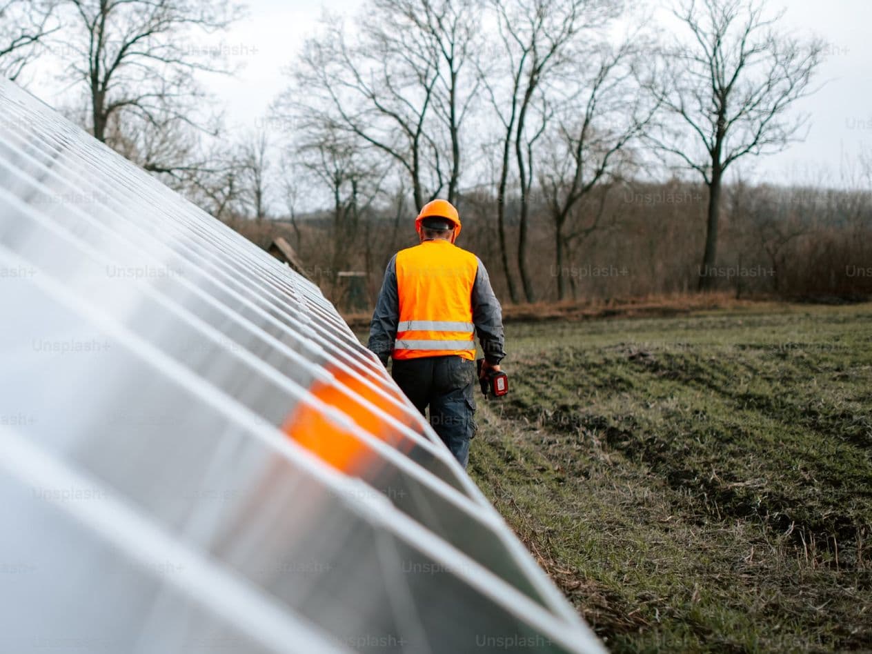 Worker inspecting solar panel